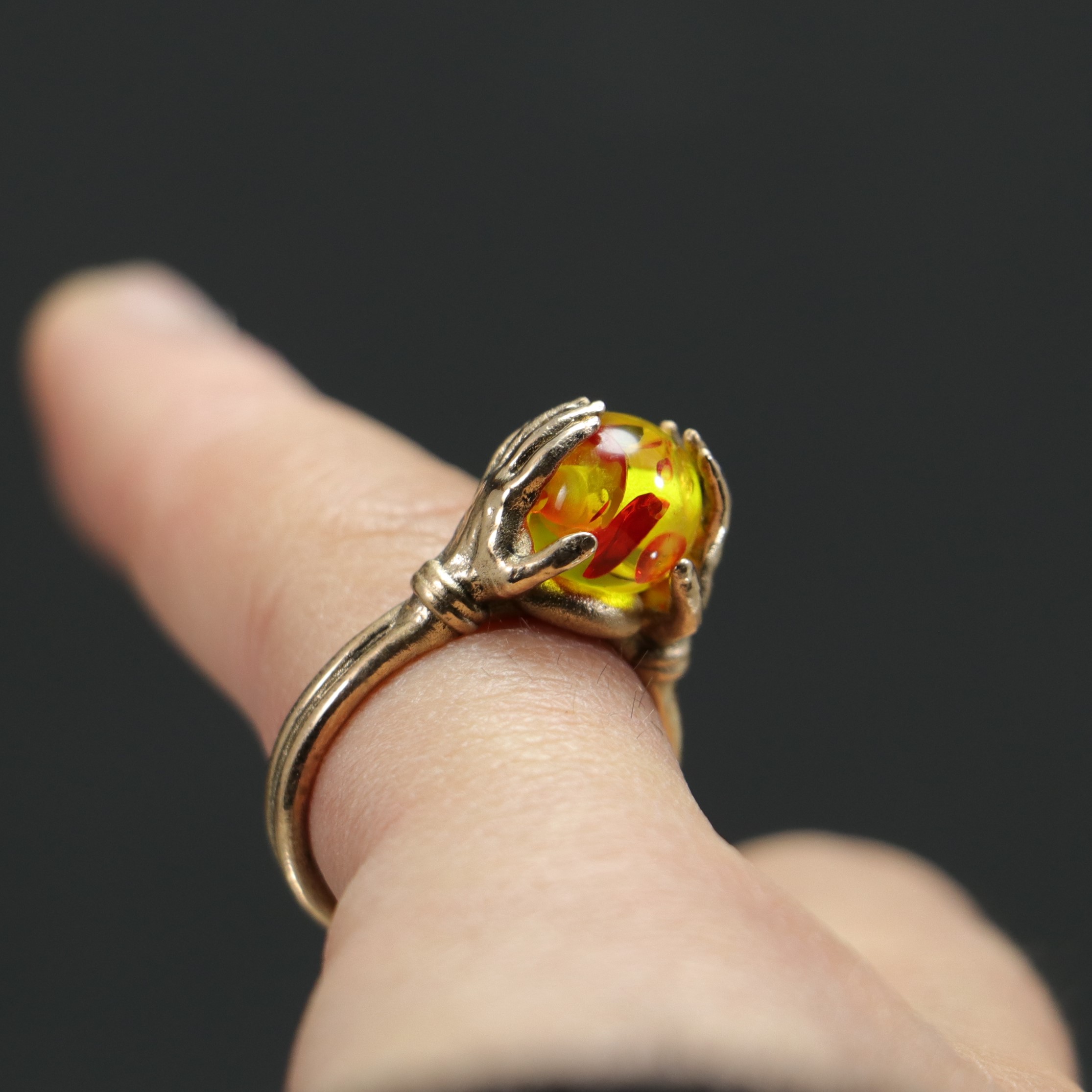 Amber Ring Between Hands